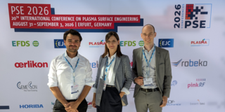 Ein Bild von Dr. Nelson Filipe Lopes Dias, Julia Urbanczyk und Finn Rümenapf (von links nach rechts) vor dem Sponsoren-Hintergrund der PSE2026